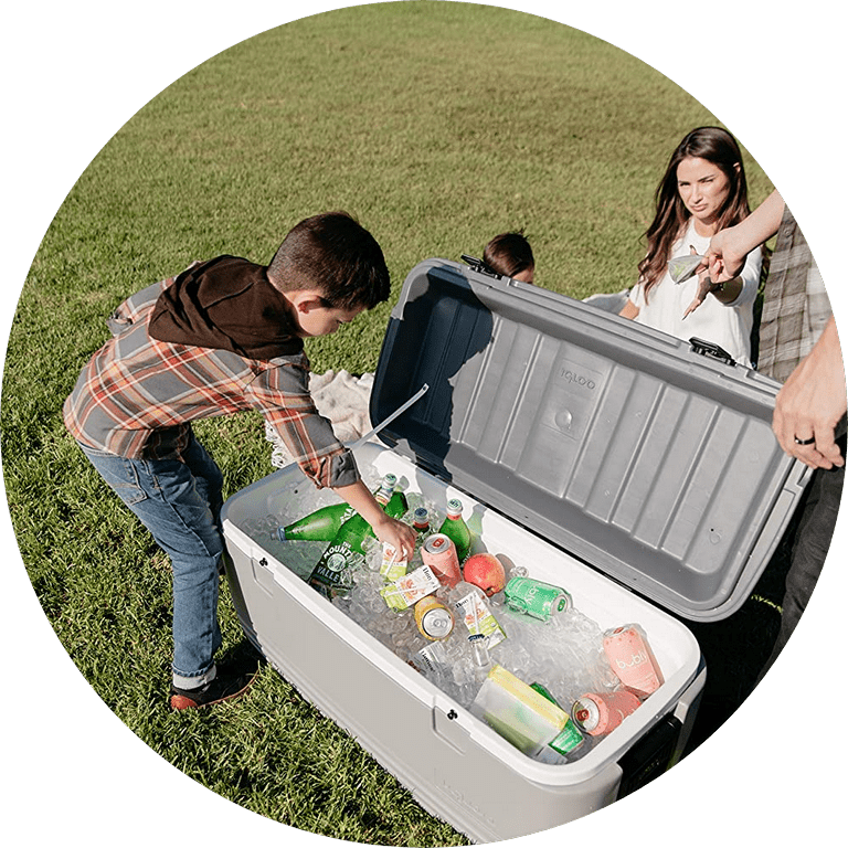 Van Rental In Houston Boy reaching into an open Igloo cooler filled with ice and drinks outdoors while a woman looks on